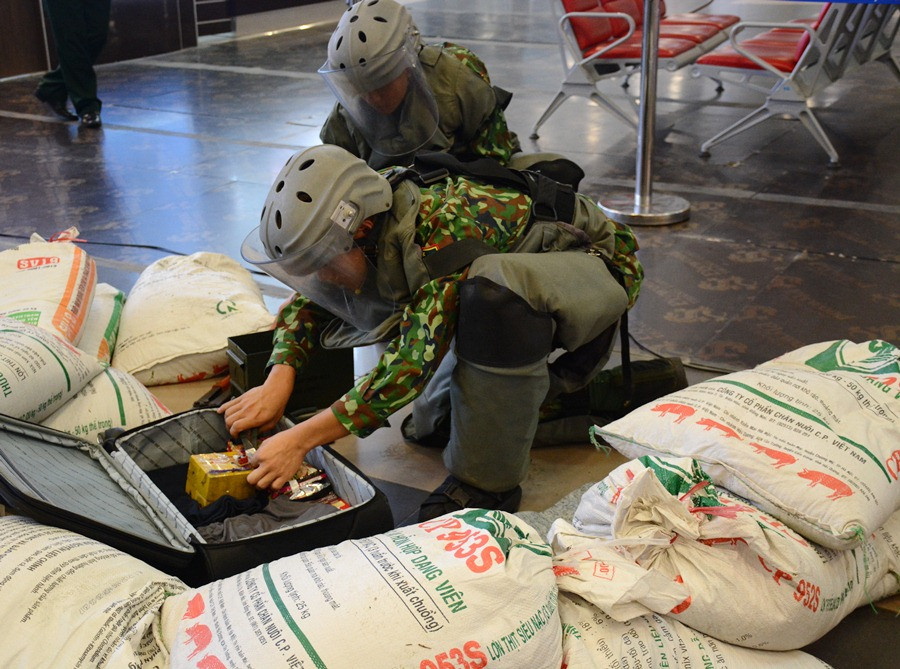 Tháo gỡ kíp nổ chứa chất nổ TNT trong chiếc valy. (Ảnh: Việt Hùng/Vietnam+)