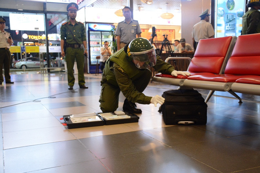 Nhân viên an ninh khẩn nguy sau khi kiểm tra bằng máy phát hiện valy chứa chất nổ TNT nhưng chưa xác định được cơ cấu nổ. (Ảnh: Việt Hùng/Vietnam+)