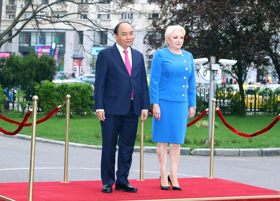 Thủ tướng Nguyễn Xuân Phúc và Thủ tướng Romania Viorica Dancila nghe Quân nhạc cử Quốc thiều 2 nước. (Ảnh: Thống Nhất/TTXVN)