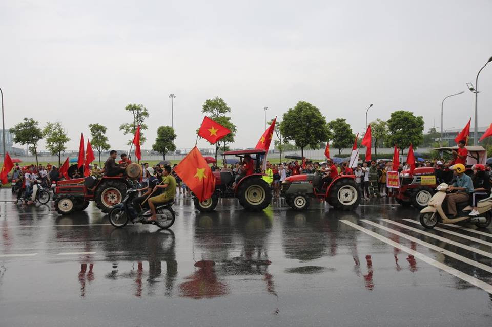 Trong hàng chục đoàn cổ vũ chờ đón đoàn thể thao Việt Nam trước cổng sân bay Nội Bài, bỗng xuất hiện những chiếc máy cày được trang trí rực rỡ. (Ảnh: PV/Vietnam+)