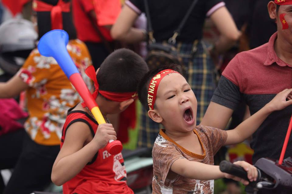 Nhiều cổ động viên nhí được bố mẹ và gia đình ‘cõng” theo để chào đón đội tuyển Olympic Việt Nam đặt chân xuống sân bay Nội Bài sau thành tích lọt vào top 4 tại ASIAD 2018 tại Indonesia. (Ảnh: PV/Vietnam+)