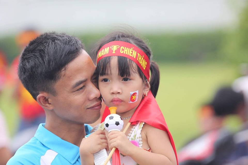 Nhiều cổ động viên nhí được bố mẹ và gia đình ‘cõng” theo để chào đón đội tuyển Olympic Việt Nam đặt chân xuống sân bay Nội Bài sau thành tích lọt vào top 4 tại ASIAD 2018 tại Indonesia. (Ảnh: PV/Vietnam+)