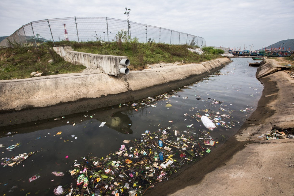 Rác và nước thải trên một con kênh dẫn ra biển thuộc địa phận xã Hải Hà có màu đen kịt. (Ảnh: Trọng Đạt/TTXVN)