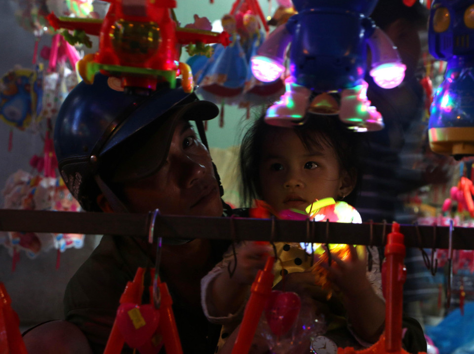 Cha đi mua đèn Trung thu cho con gái. (Ảnh: Duy Khương/TTXVN)