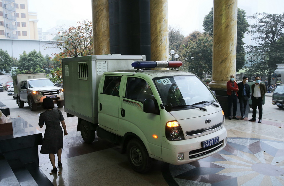 Cảnh sát dẫn giải các bị cáo tới tòa xét xử. (Ảnh: Doãn Tấn/TTXVN)