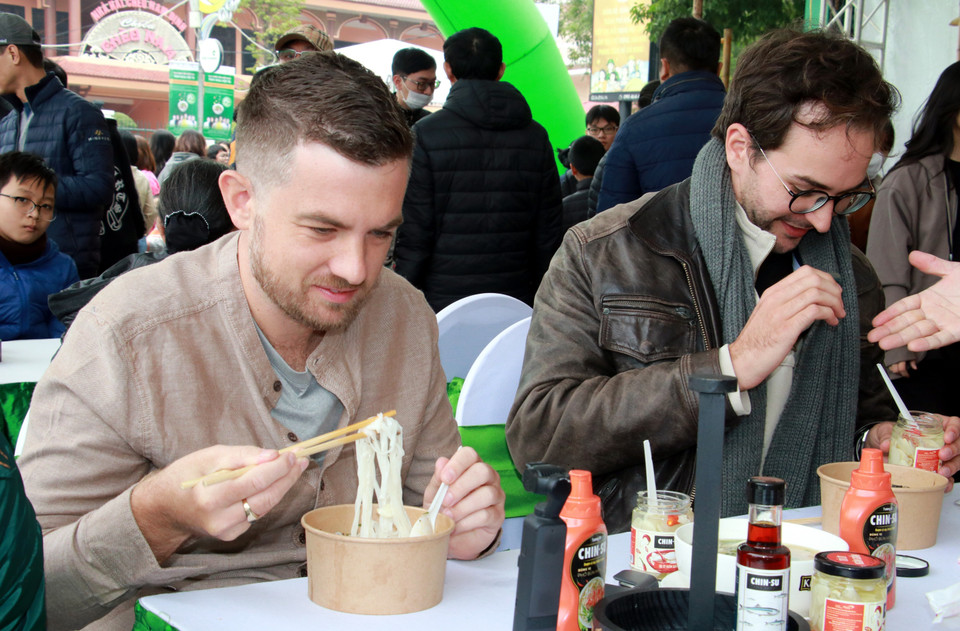 Du khách nước ngoài thưởng thức món phở. (Ảnh: Văn Đạt/TTXVN)