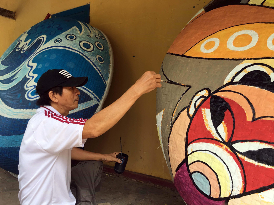 Những tác phẩm hội họa nhiều màu sắc, độc đáo được các họa sỹ thể hiện trên những chiếc thuyền thúng. (Ảnh: Đỗ Trưởng/TTXVN)