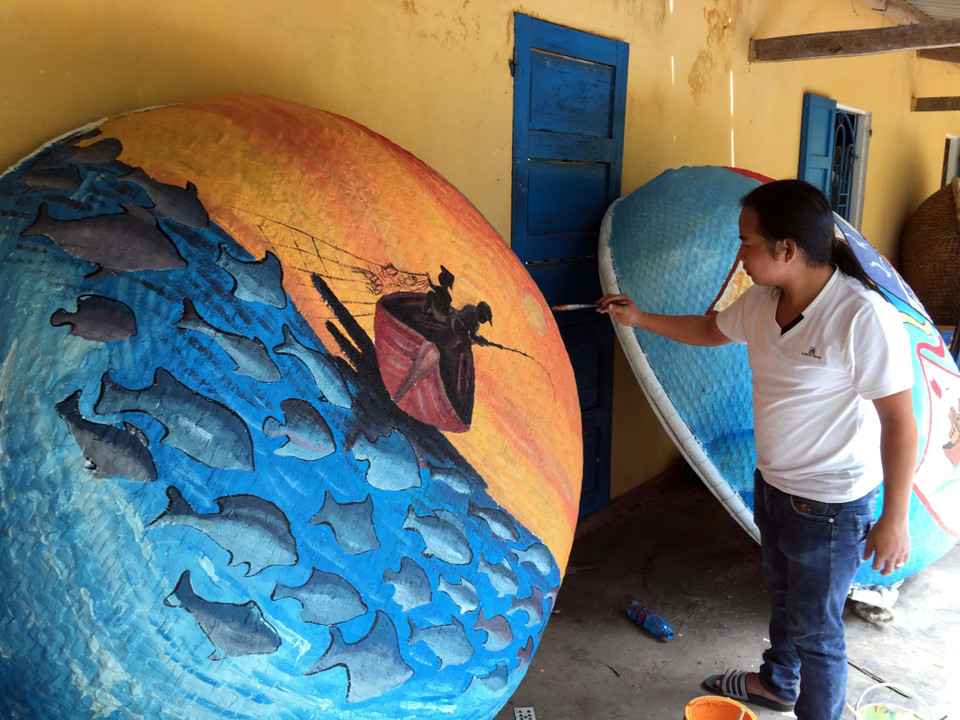 Những tác phẩm hội họa nhiều màu sắc, độc đáo được các họa sỹ thể hiện trên những chiếc thuyền thúng. (Ảnh: Đỗ Trưởng/TTXVN)