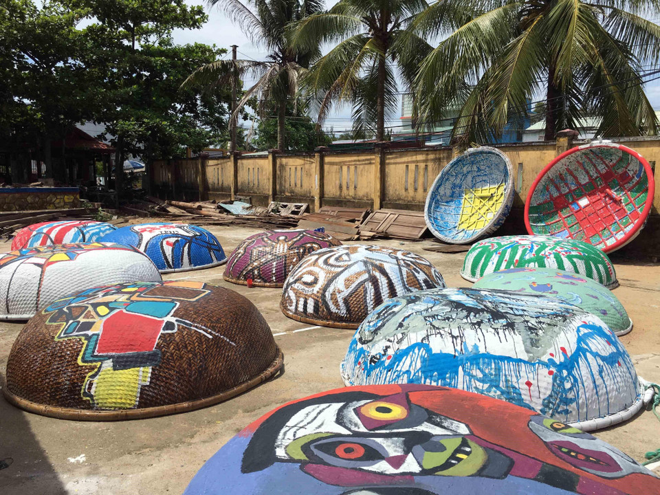 Những tác phẩm hội họa nhiều màu sắc, độc đáo được các họa sỹ thể hiện trên những chiếc thuyền thúng. (Ảnh: Đỗ Trưởng/TTXVN)