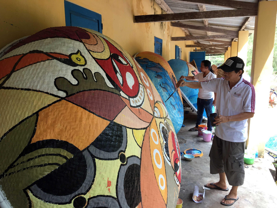 Những tác phẩm hội họa nhiều màu sắc, độc đáo được các họa sỹ thể hiện trên những chiếc thuyền thúng. (Ảnh: Đỗ Trưởng/TTXVN)