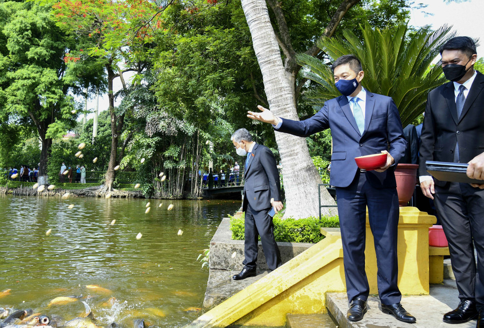 Chủ tịch Quốc hội Cộng hòa Singapore Tan Chuan-Jin cho cá ăn sau khi tham quan Nhà sàn Bác Hồ. (Ảnh: TTXVN)