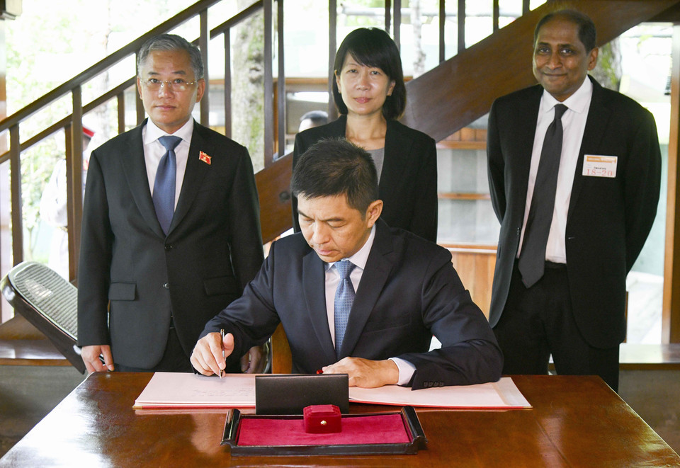 Chủ tịch Quốc hội Cộng hòa Singapore và phu nhân viết lưu bút tại Nhà sàn Bác Hồ. (Ảnh: TTXVN)