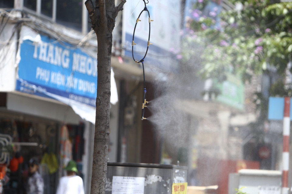 Nhiều cửa hàng dùng thiết bị phun sương để giảm nhiệt. (Ảnh: Minh Quyết/TTXVN)