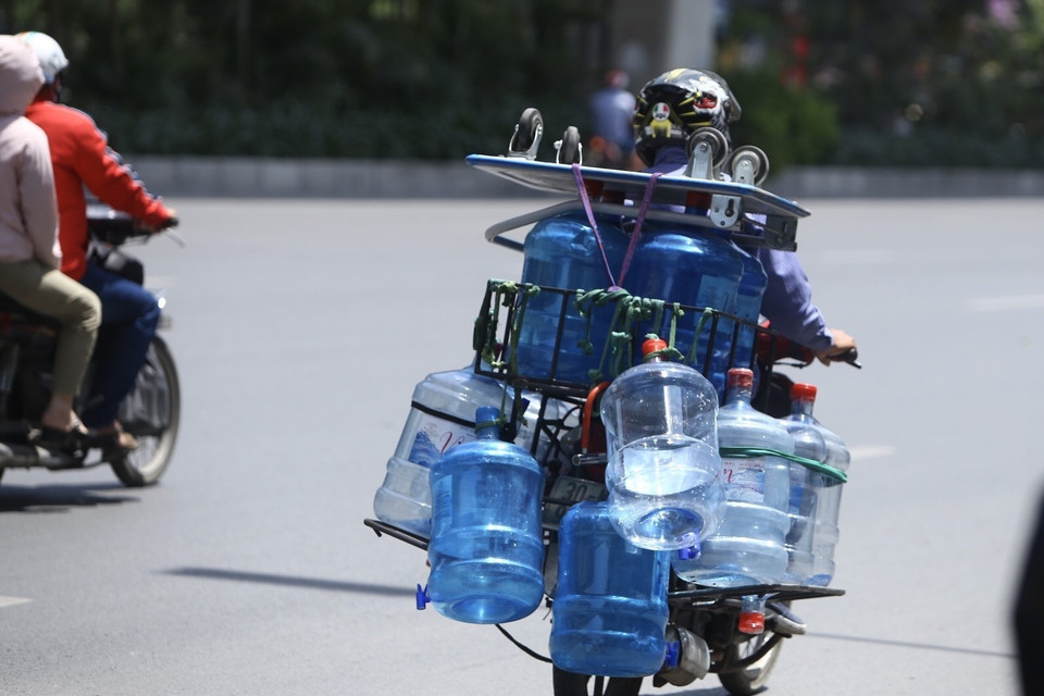 Các đại lý nước sạch đóng bình luôn bận rộn trong những ngày nắng nóng này.(Ảnh: Minh Quyết/TTXVN)