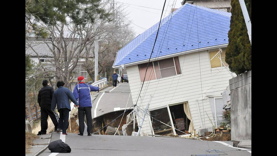 Người dân kiểm tra thiệt hại của một ngôi nhà ven đường ở thành phố Sukagawa, tỉnh Fukushima, miền bắc Nhật Bản. (Nguồn: theglobeandmail)