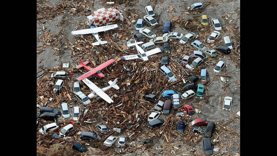 Ôtô và cả máy bay bị sóng thần cuốn trôi giữa các mảnh vỡ ở sân bay Sendai, đông bắc Nhật Bản. (Nguồn: theglobeandmail)