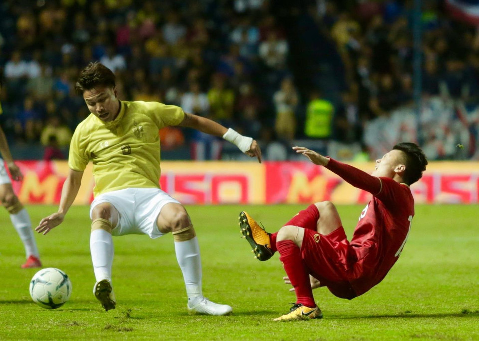 Tiền vệ Quang Hải của Việt Nam bị ngã sau pha phạm lỗi của tiền vệ Thitiphan bên phía Thái Lan. (Ảnh: Nguyễn Minh Tiến/TTXVN)