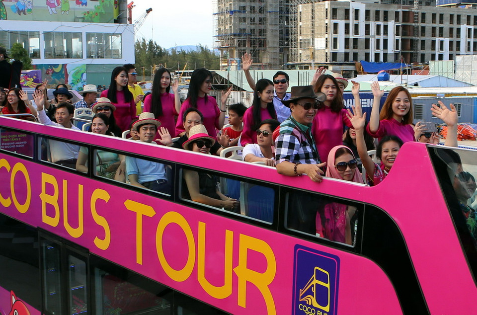 Người dân và du khách háo hức trải nghiệm xe buýt Coco Bus Tour trong ngày khai trương. (Ảnh: Trần Lê Lâm/Vietnam+)