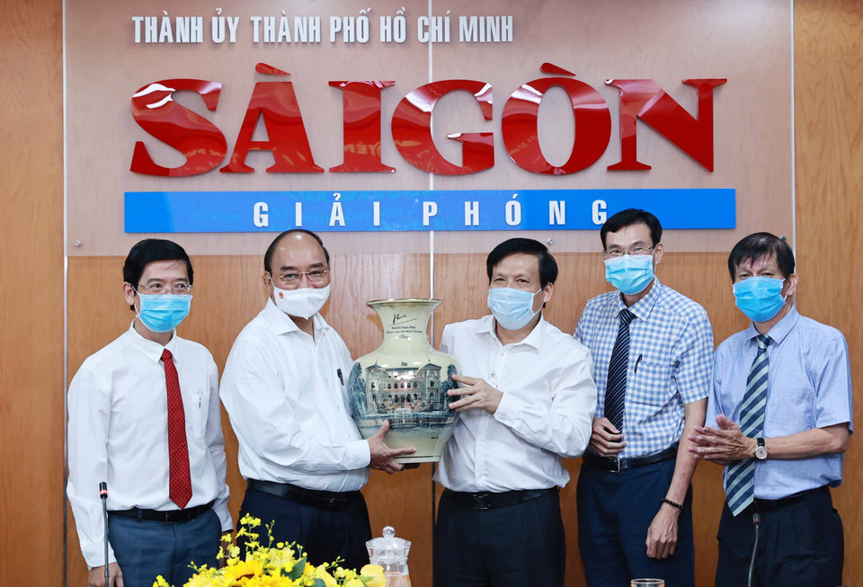 Chủ tịch nước Nguyễn Xuân Phúc tặng quà lưu niệm cho Báo Sài Gòn Giải phóng. (Ảnh: Thống Nhất/TTXVN)