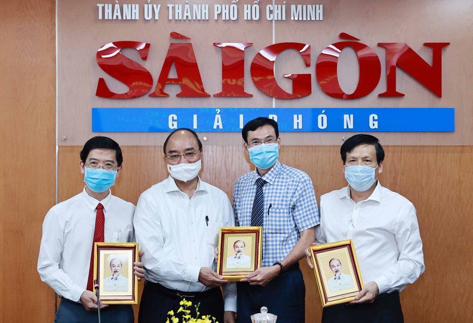 Chủ tịch nước Nguyễn Xuân Phúc tặng chân dung Chủ tịch Hồ Chí Minh cho Ban biên tập Báo Sài Gòn Giải phóng. (Ảnh: Thống Nhất/TTXVN)