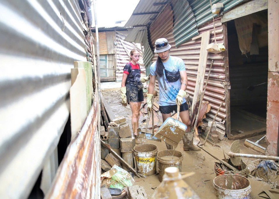 Nhiều tình nguyện viên nước ngoài đã tới giúp đỡ người dân khu xóm trọ nghèo dưới chân cầu Long Biên (ảnh chụp ngày 15/9/2024). (Ảnh: Tuấn Đức/TTXVN)