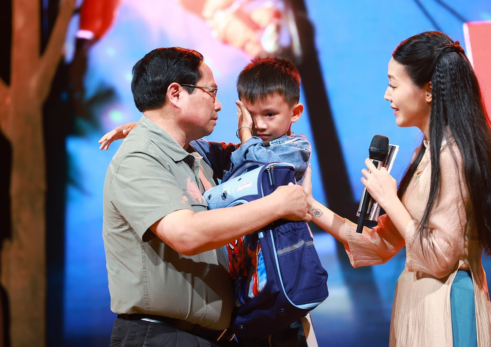 Thủ tướng Phạm Minh Chính động viên cháu Nguyễn Quốc Bảo (sinh năm 2016) bị mất cả bố và chị gái khi 3 người bị nước lũ cuốn trôi trong lúc di chuyển bằng xe máy qua cầu tràn thôn Cầu Treo, xã Yên Thuận, huyện Hàm Yên, tỉnh Tuyên Quang. (Ảnh: Dương Giang/TTXVN)