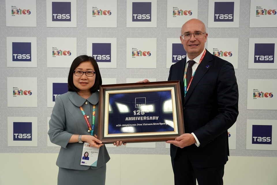 Phó Tổng giám đốc TTXVN Đoàn Thị Tuyết Nhung tặng quà Tổng giám đốc TASS Andrey Kondrashov. (Ảnh: TTXVN)