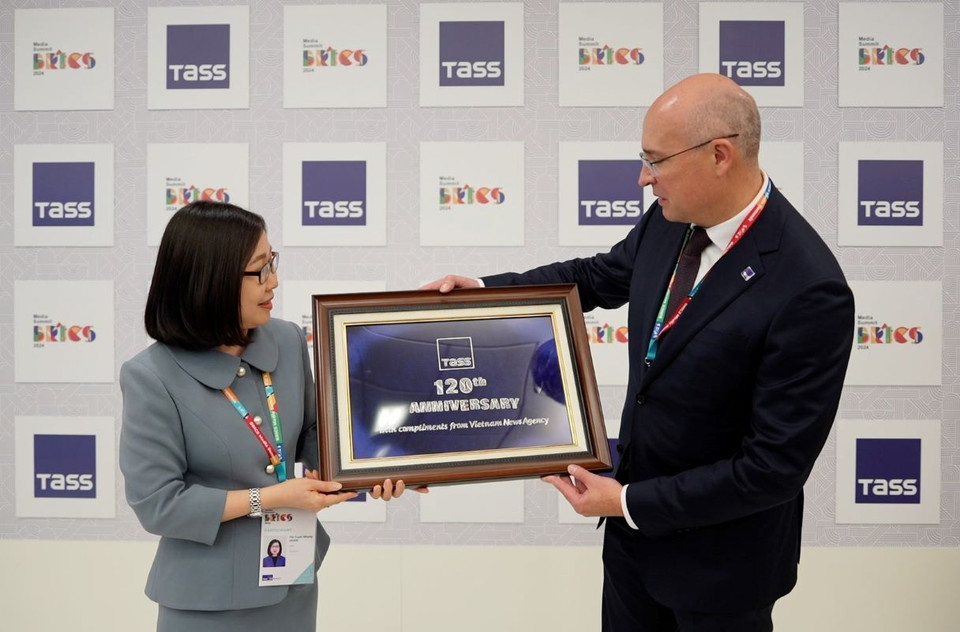 Phó Tổng giám đốc TTXVN Đoàn Tuyết Nhung tặng quà Tổng giám đốc TASS Andrey Kondrashov. (Ảnh: TTXVN)