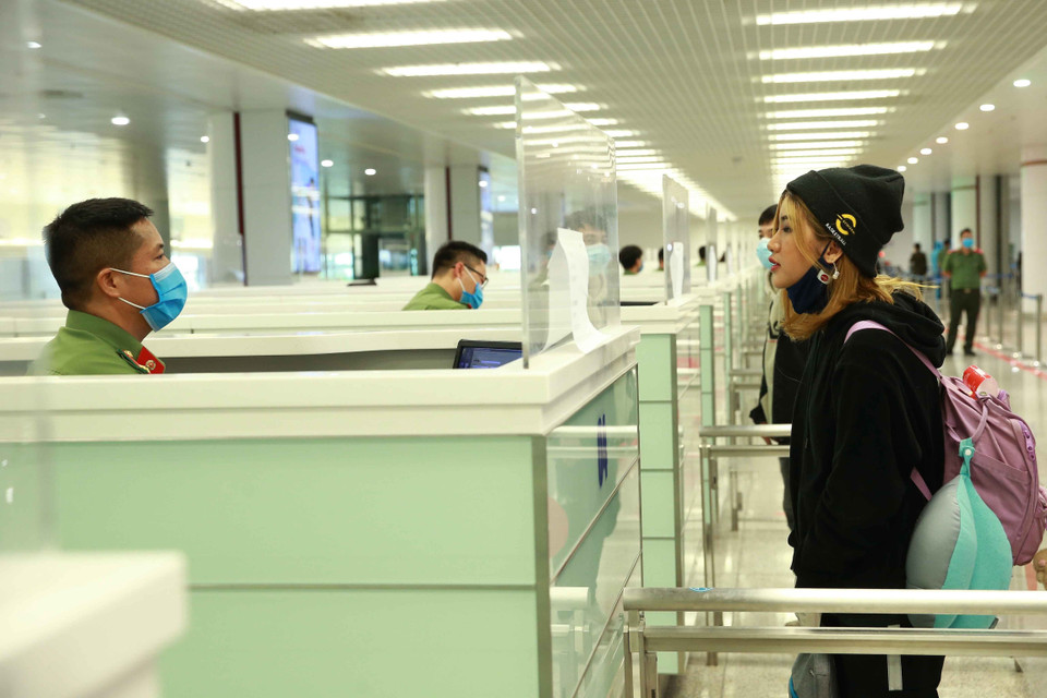 Lực lượng Công an cửa khẩu Cảng hàng không Quốc tế Nội Bài kiểm tra hộ chiếu của hành khách nhập cảnh. (Ảnh: Doãn Tấn/TTXVN)