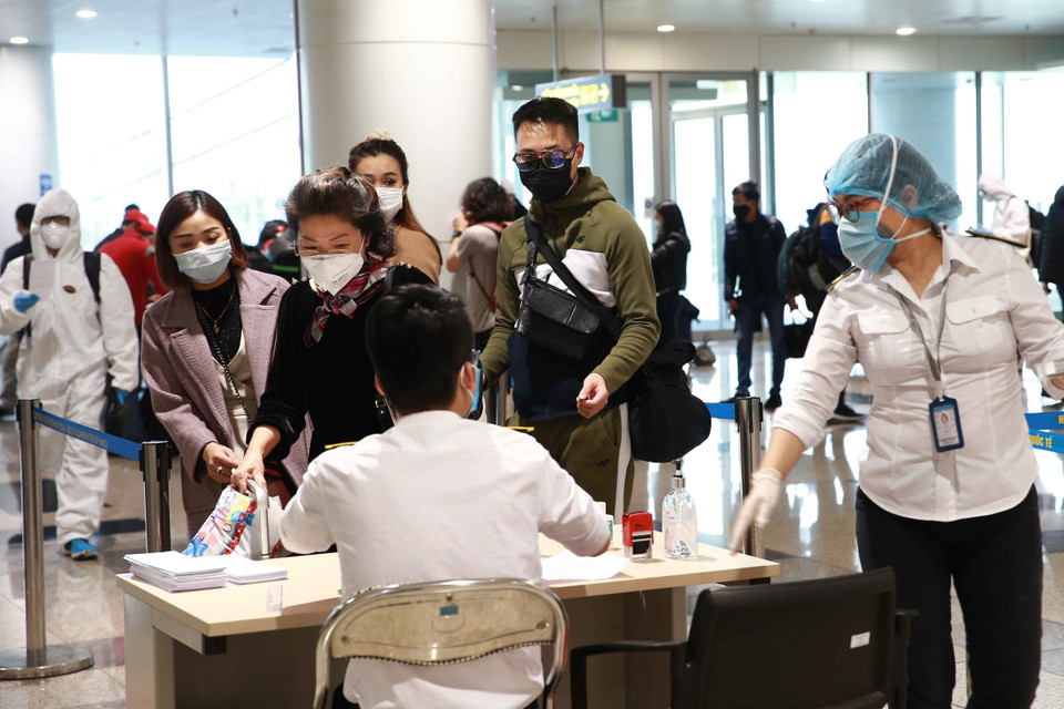  Lực lượng y tế làm thủ tục khai báo y tế bắt buộc đối với hành khách tại Cảng hàng không quốc tế Nội Bài. (Ảnh: Doãn Tấn/TTXVN)