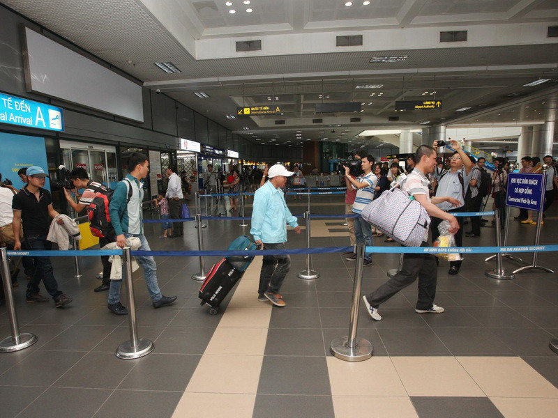  Lao động Việt Nam từ Libya trở về ra cửa Sân bay Quốc tế Nội Bài. (Ảnh: Thanh Tùng/TTXVN)