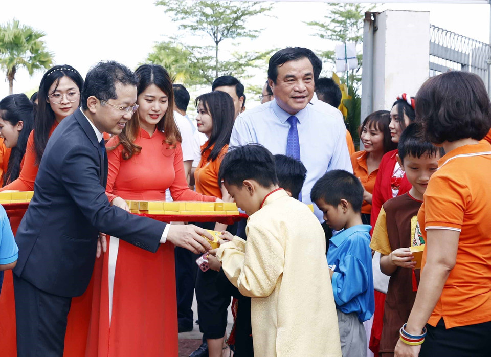 Các đại biểu phát quà cho học sinh trường tiểu học, trung học cơ sở và trung học phổ thông Hy Vọng tại Ngày hội tới trường. (Ảnh: Thống Nhất/TTXVN)