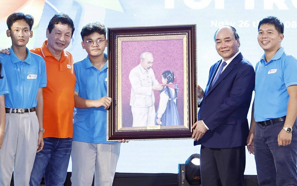 Chủ tịch nước Nguyễn Xuân Phúc tặng quà lưu niệm cho trường tiểu học, trung học cơ sở và trung học phổ thông Hy Vọng.(Ảnh: Thống Nhất/TTXVN)