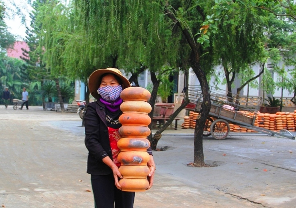 Giáo dân bê nồi đất do gia đình làm đến khu vực dựng cây thông Noel khổng lồ. (Ảnh: Mai Mạnh/Vietnam+)