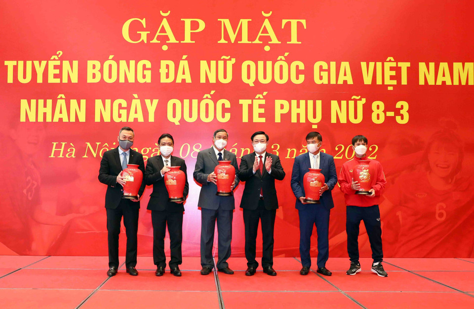 Chủ tịch Quốc hội Vương Đình Huệ tặng hoa và quà chúc mừng Ban huấn luyện và các nữ cầu thủ. (Ảnh: Phạm Kiên/TTXVN)