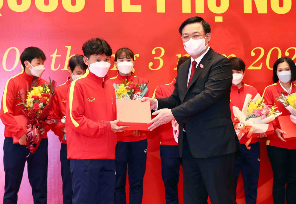 Hình ảnh Chủ tịch Quốc hội Vương Đình Huệ tặng hoa và quà chúc mừng các nữ cầu thủ. (Ảnh: Phạm Kiên/TTXVN)