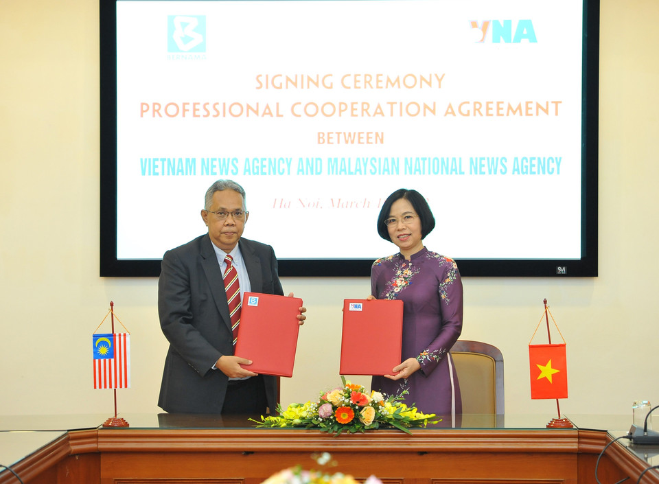 Tổng giám đốc TTXVN Vũ Việt Trang và Tổng biên tập BERNAMA Khairdzir bin Md Yunus ký kết Thỏa thuận hợp tác nghiệp vụ. (Ảnh: Minh Đức/TTXVN)