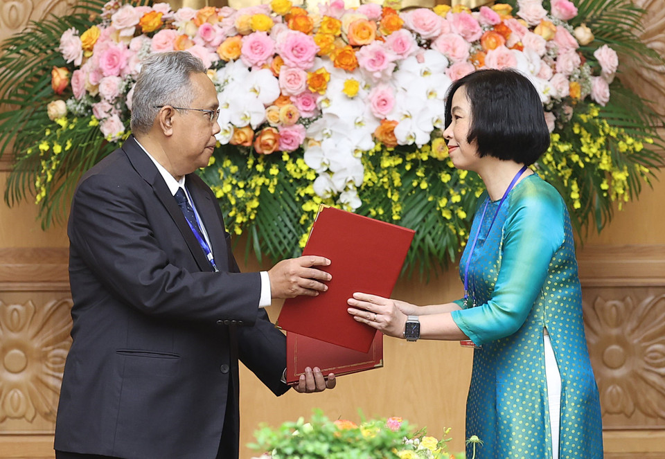 Tổng Giám đốc Thông tấn xã Việt Nam Vũ Việt Trang và Tổng biên tập Hãng thông tấn quốc gia Malaysia (BERNAMA) Khairdzir Md Yunus trao đổi Thỏa thuận hợp tác nghiệp vụ giữa Thông tấn xã Việt Nam và Hãng thông tấn quốc gia Malaysia. (Ảnh: Dương Giang/TTXVN)