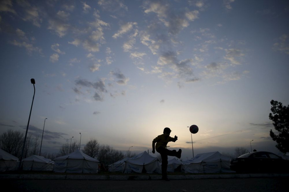 Một cậu bé di cư đang chơi đá bóng gần thị trấn Polikastro, Hy Lạp ngày 23/2. (Nguồn: Sputniknews)