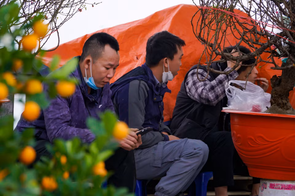 Thậm chí, nhiều người còn tụ tập lại nói chuyện, mòn mỏi chờ khách. (Ảnh: Minh Hiếu/Vietnam+)