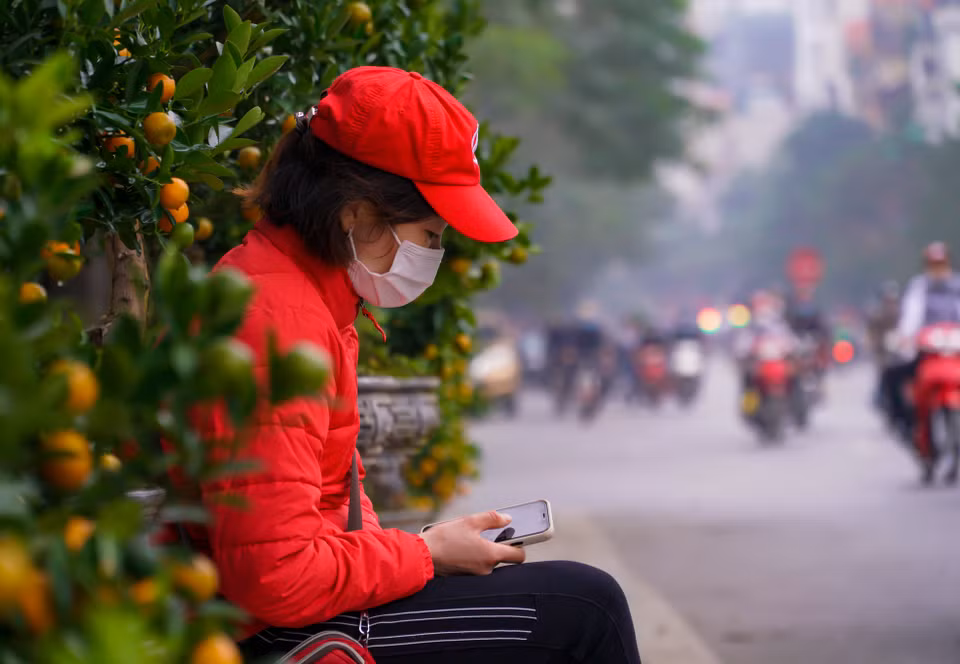Một số tiểu thương do ế khách nên chỉ biết ngồi lướt điện thoại để giết thời gian. (Ảnh: Minh Hiếu/Vietnam+)