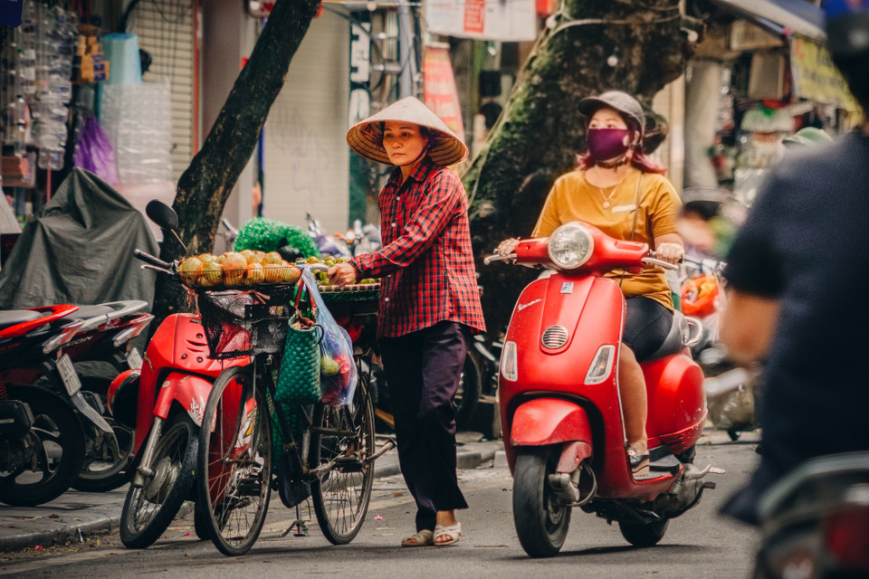 Những gánh hàng hoa mộc mạc vẫn cần mẫn làm đẹp cho đời, cho người, hoa càng đẹp càng đáng quý hơn khi đằng sau gánh hoa còn cả một cuộc sống mưu sinh vất vả. (Ảnh: Minh Hiếu/Vietnam+)