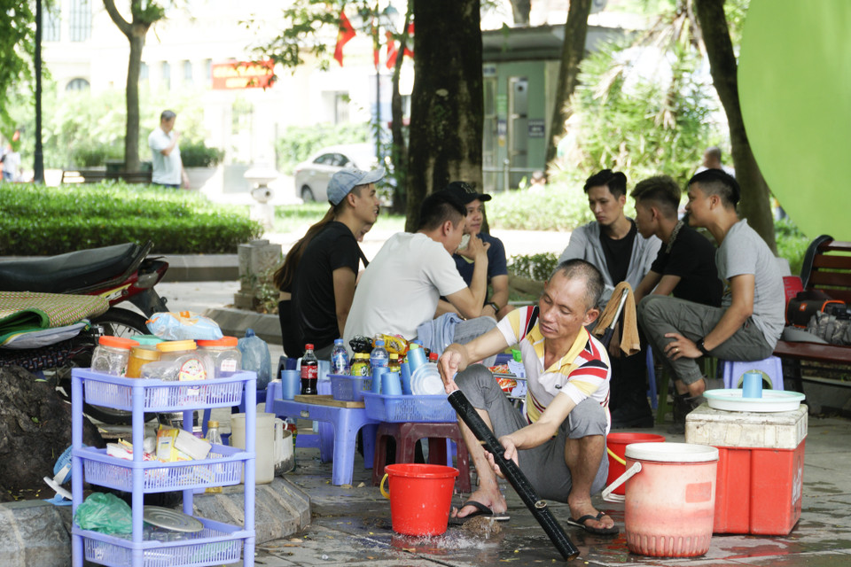 Đám thanh niên vô tư tụ tập đông người tại quán trà đá trên vỉa hè. (Ảnh: Minh Hiếu/Vietnam+)