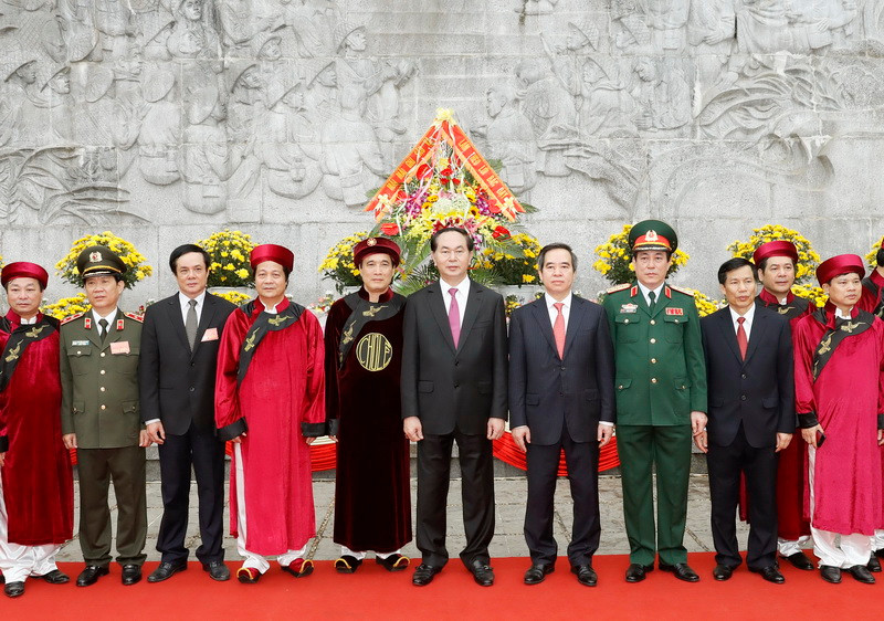 Chủ tịch nước Trần Đại Quang và các đại biểu chụp ảnh chung tại bức phù điêu khắc câu nói của Chủ tịch Hồ Chí Minh Các vua Hùng đã có công dựng nước, Bác cháu ta phải cùng giữ lấy nước khi nói chuyện với các chiến sỹ Đại đoàn quân Tiên Phong năm 1954. (Ảnh: Nhan Sáng/TTXVN)