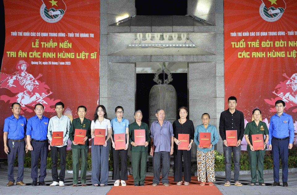 Bí thư đoàn Khối các Cơ quan Trung ương Bùi Hoàng Tùng trao các suất quà cho các gia đình chính sách, thương binh, bệnh binh, các gia đình Liệt sỹ. (Ảnh: Minh Đức/TTXVN)