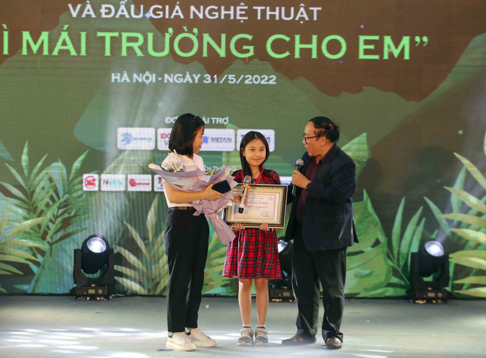 Nhà thơ Trần Đăng Khoa trao giải Khát vọng Dế Mèn cho em Nguyễn Vũ Hải Băng với chùm 4 truyện ngắn. (Ảnh: Tuấn Đức/TTXVN)