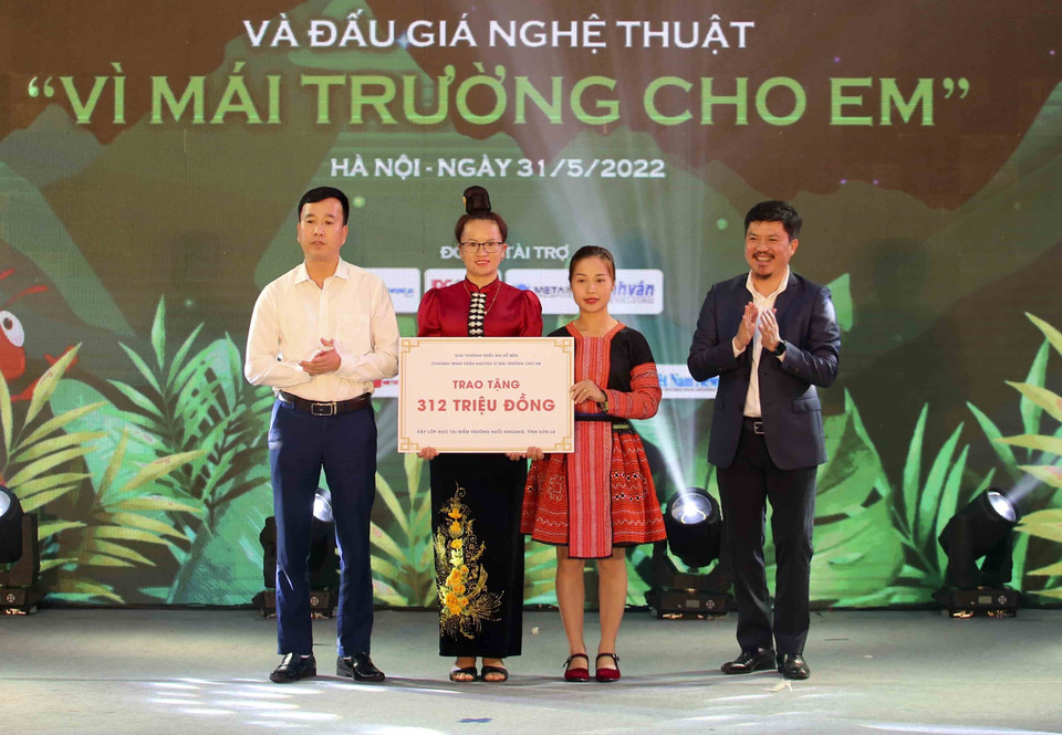 Ban tổ chức trao tặng số tiền tại buổi đấu giá cho đại diện điểm trường Huổi Khương, thuộc trường Mầm non Sao Mai, xã Nậm Mằn, huyện Sông Mã (Sơn La). (Ảnh: Tuấn Đức/TTXVN)