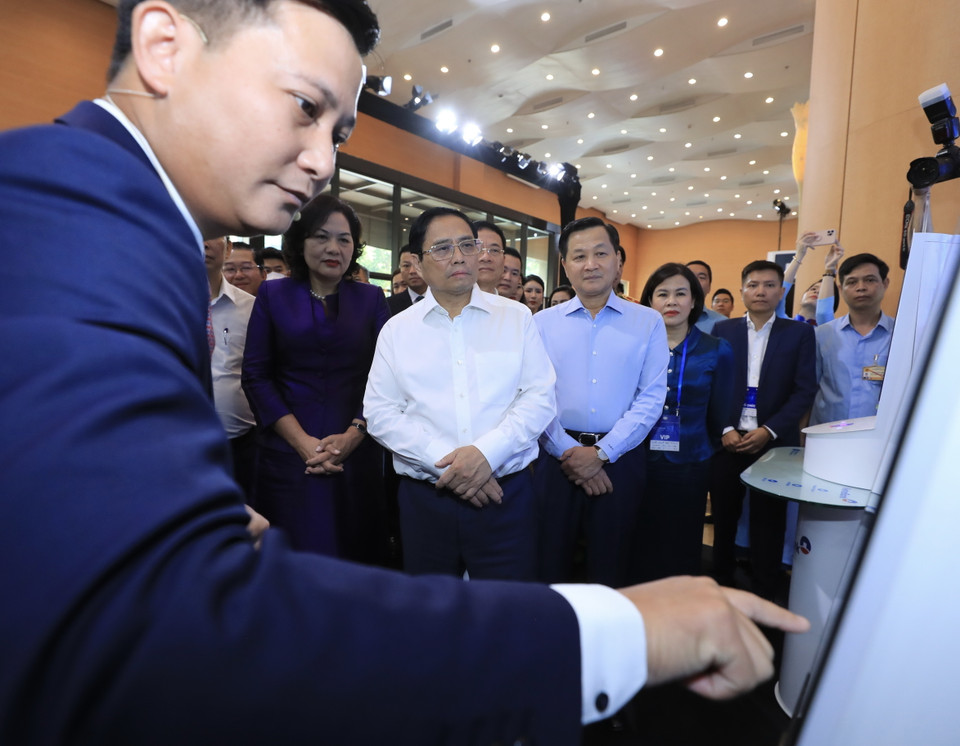 Thủ tướng Phạm Minh Chính cùng các đại biểu tham quan trưng bày công nghệ chuyển đổi số của một số ngân hàng. (Ảnh: Lâm Khánh/TTXVN)
