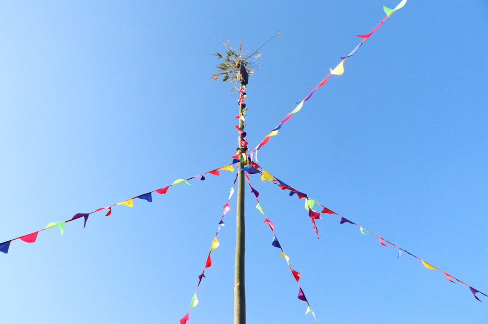 Phần ngọn cây nêu được buộc dải khăn và treo nhiều loại ngũ cốc, nông sản. (Ảnh: Xuân Tiến/TTXVN)