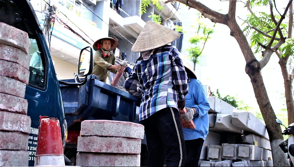 Vật liệu thừa và phế thải được chuyển lên ôtô, đưa ra khỏi phố đi bộ. (Ảnh: Nguyễn Thúy/Vietnam+)